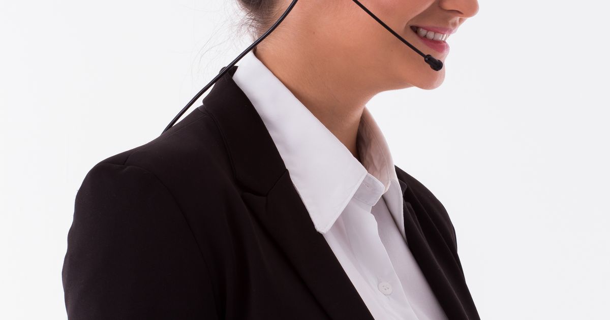 Lächelnde Vertriebsmitarbeiterin mit Headset telefoniert im Büro: Kaltakquise für Reinigungsfirmen