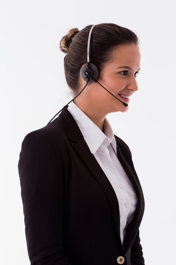 A Smiling Woman In Black Blazer Wearing A Headset