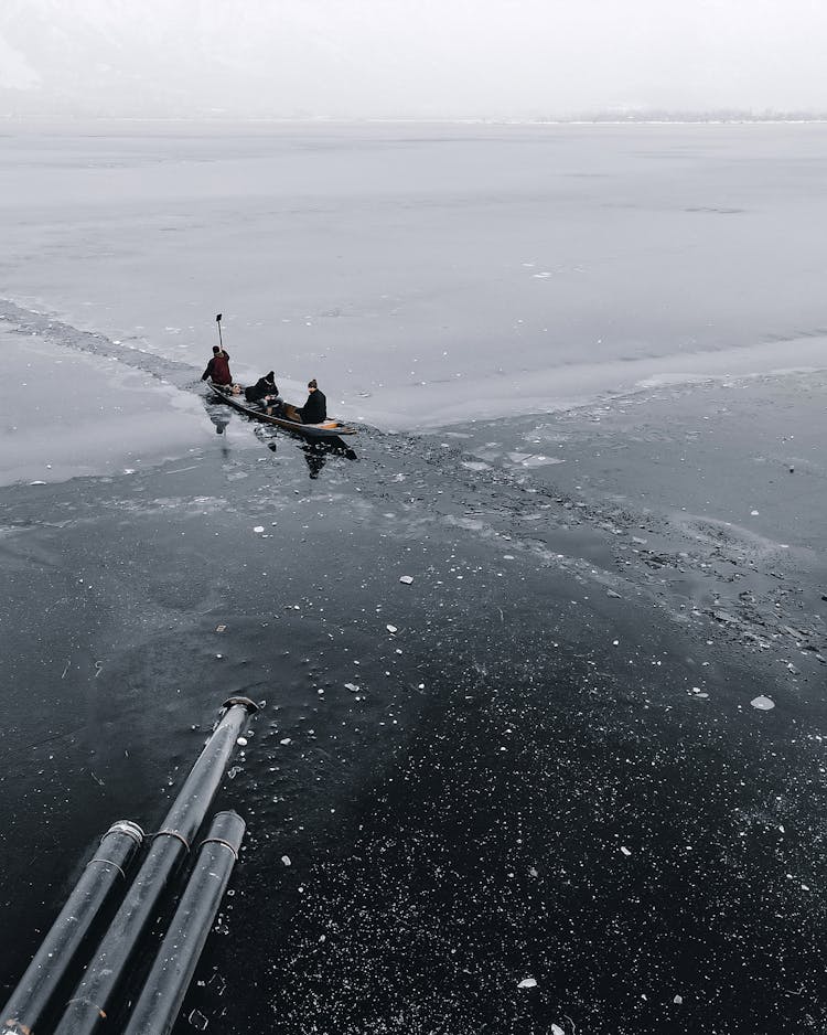 People Canoeing On A Frozen Lake