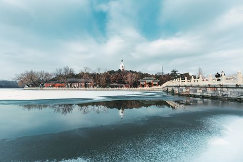 Free Scenic winter view of Beihai Park's bridge with reflection on icy water, Beijing, China. Stock Photo