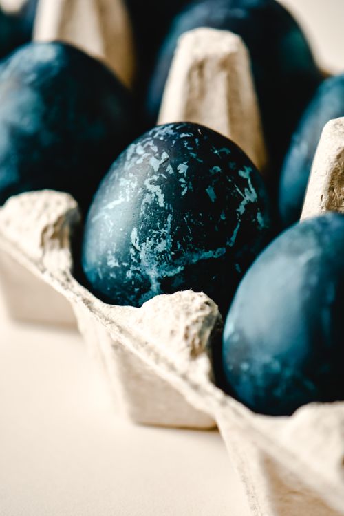 Free Artistic close-up of blue dyed Easter eggs in a cardboard carton, showcasing texture and minimalism. Stock Photo