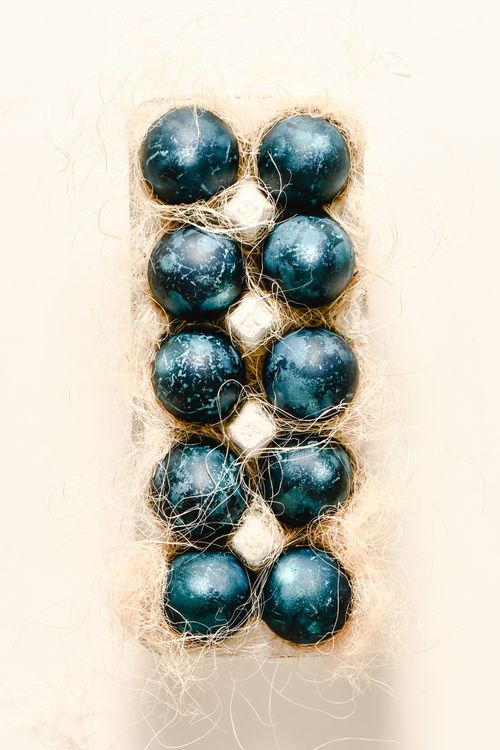 Free Flat lay of blue and white dyed eggs in a natural tray, showcasing minimalistic Easter decoration. Stock Photo