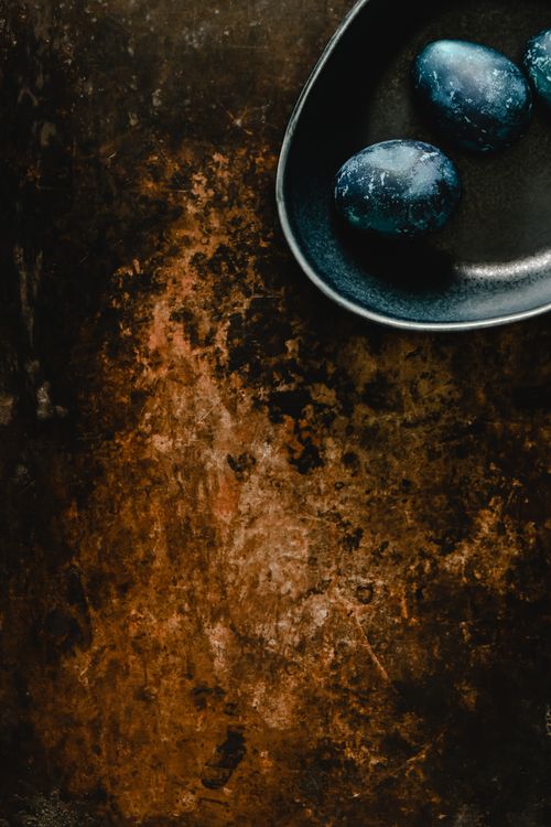 Free Artistic top-down shot of blue eggs in a bowl on a rustic backdrop. Stock Photo