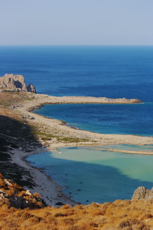 Free Stunning aerial view of a rugged coastline with clear blue waters and a beautiful sandy beach. Stock Photo