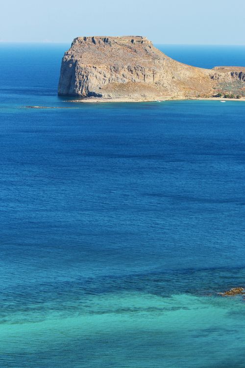 Free A stunning cliffside by the azure sea under a clear blue sky, showcasing natural beauty. Stock Photo