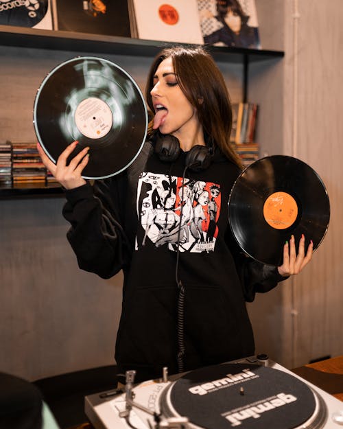 Woman in Black Hoodie holding Vinyl Records
