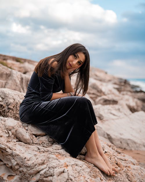 Free Portrait of a Woman Sitting on a Rock Stock Photo