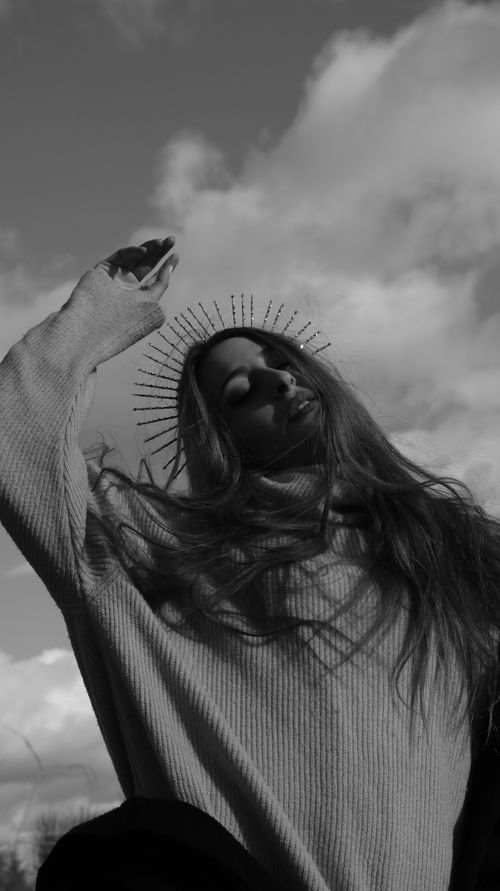 Free Elegant monochrome portrait of a woman raising her arm, embodying grace and confidence. Stock Photo