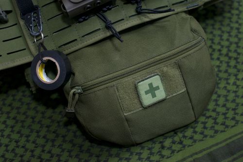 Free Close-up of a green first aid kit pouch attached to military gear, highlighting preparedness. Stock Photo