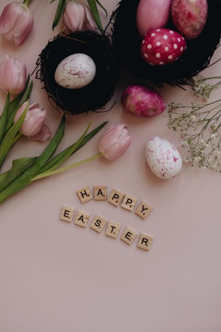 A festive Easter flat lay featuring colorful eggs and tulips with 'Happy Easter' spelled out.