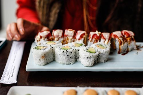 Free Tasty sushi rolls on a ceramic plate, showcasing Japanese cuisine in an intimate indoor dining setting. Stock Photo