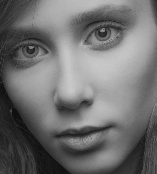 Free Close-up black and white portrait capturing the intense gaze of a young woman. Stock Photo