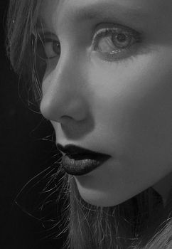 Artistic black and white portrait of a woman with dramatic lighting.