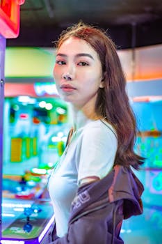 A fashionable woman posing confidently inside a vibrant amusement arcade setting.