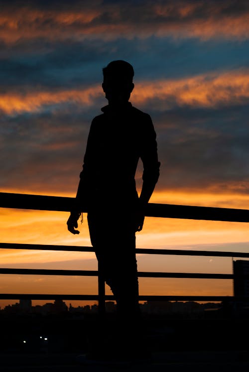 Free A Silhouette of a Man beside a Railing Stock Photo