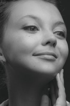 Striking grayscale portrait of a smiling woman with a calm and confident expression, exuding elegance.