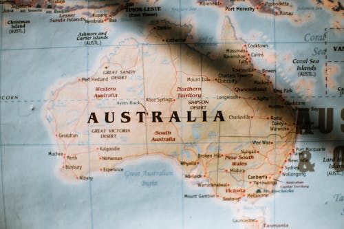 Free Closeup of political map of Australia with cities and regions with borders surrounded by seas and oceans placed on wall in sunny room Stock Photo