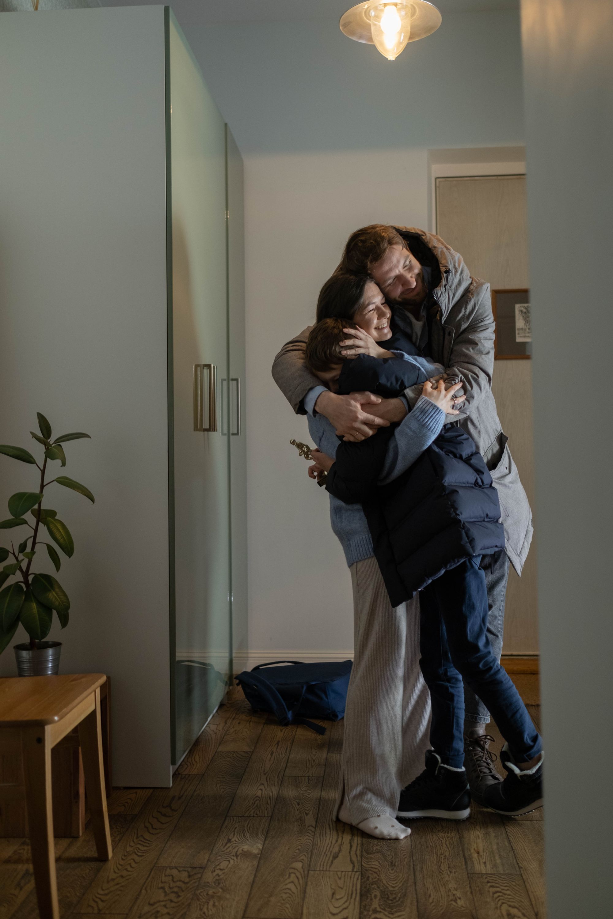 Família abraçada num interior acolhedor