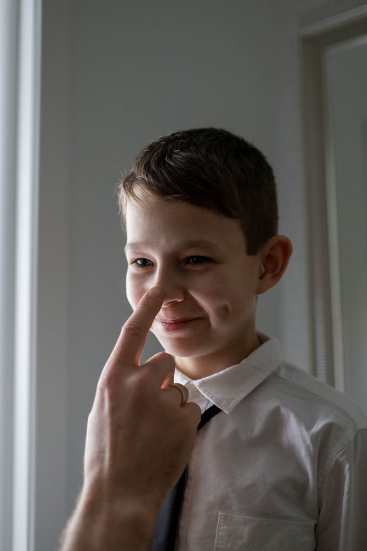 A Person's Finger Touching A Boy's Note