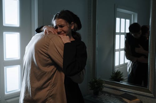 Free An Emotional Woman Crying while Hugging another Person Stock Photo