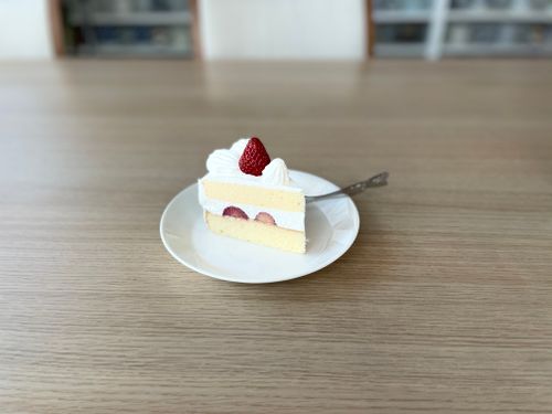 Free Sliced strawberry shortcake with whipped cream on a white plate, photographed indoors. Stock Photo