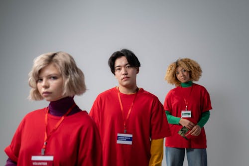 Three People in Red Crew Neck Shirt Uniform