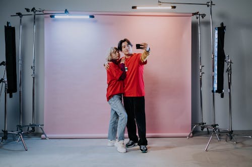 A Man and a Woman Wearing Red Shirts Taking a Selfie