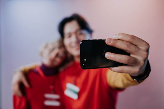 Two friends taking a selfie indoors with a smartphone. Smiling and enjoying the moment.