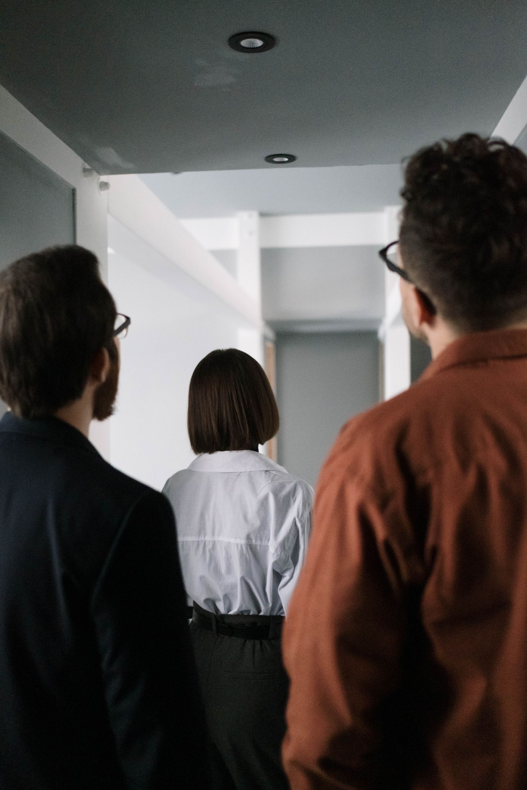 Führungskraft von hinten mit ihrem Team in einem modernen Büro