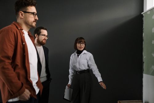 Free Three colleagues in a studio having a professional discussion. Smart casual attire. Stock Photo