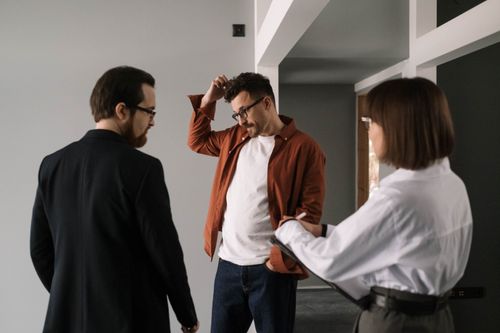 Free Three professionals discussing interior design project in a contemporary office setting. Stock Photo
