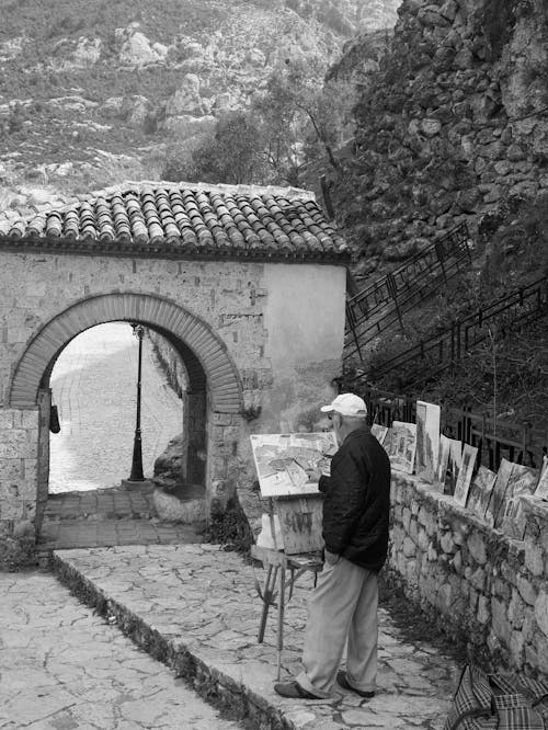 A Grayscale Photo of a Man Painting