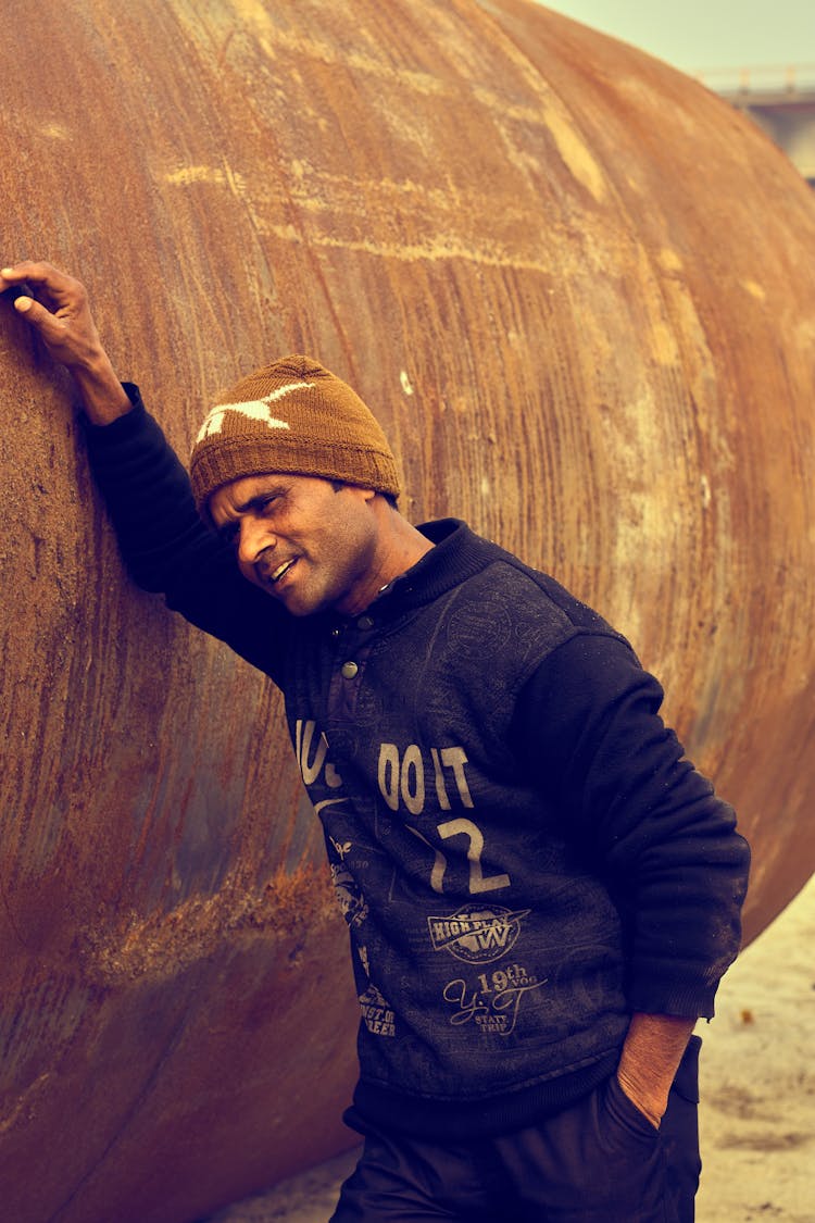 Man Leaning On A Rusty Tank