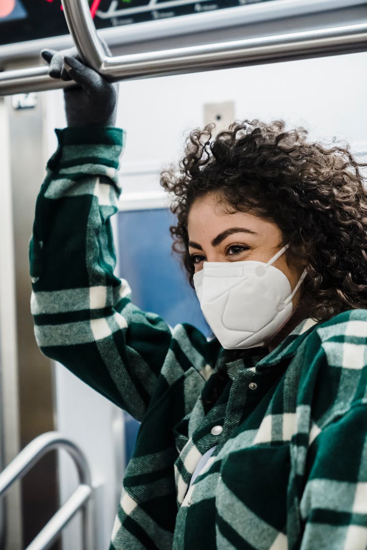 Cheerful Ethnic Woman In Medical Mask Riding In Subway Train