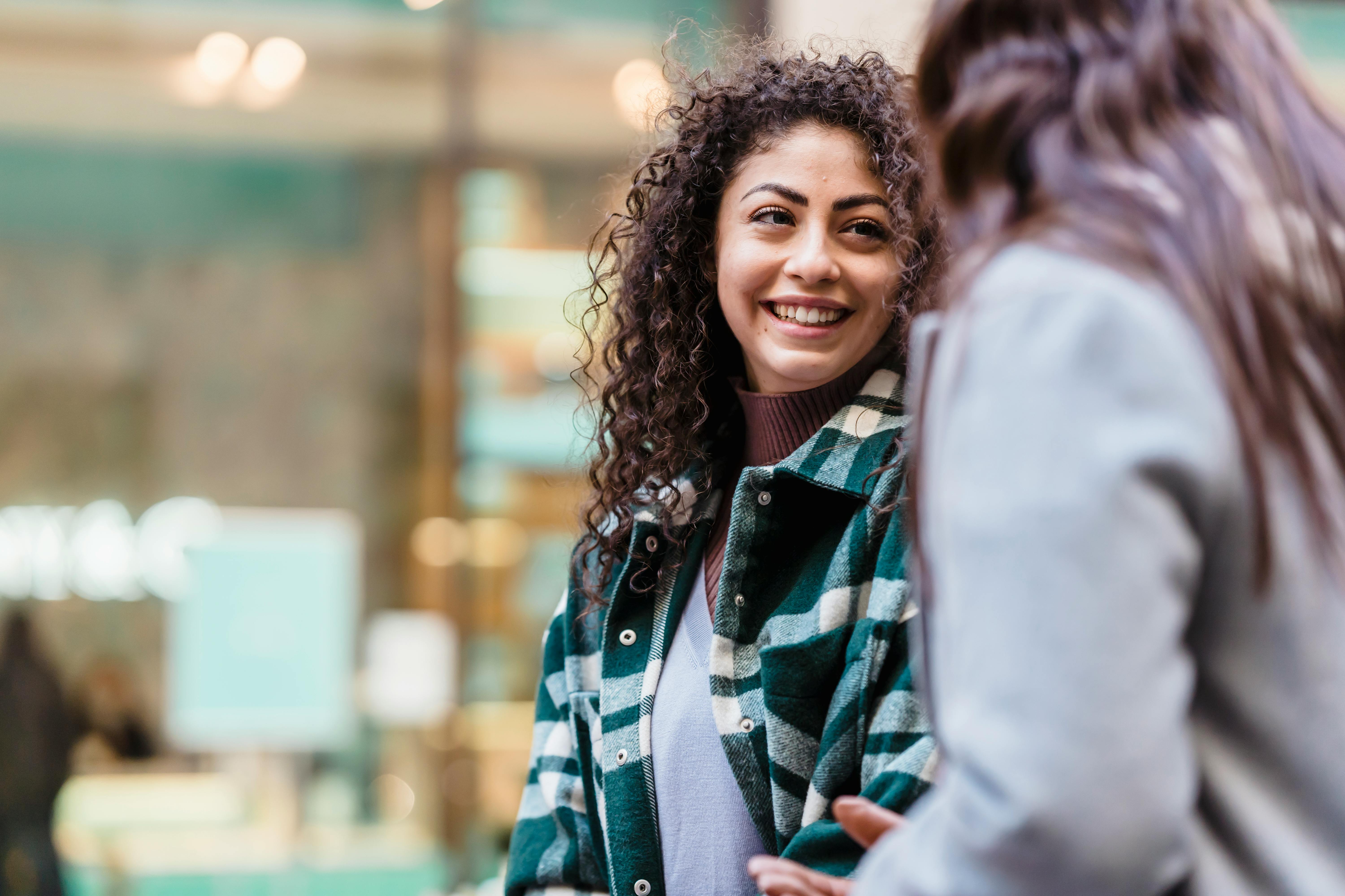 happy female talking with friend on city street