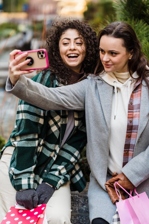 Free Happy young multiethnic female friends taking selfie in city after shopping Stock Photo