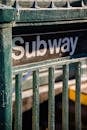 Signboard with inscription subway placed on steel railing of fence on street in daytime