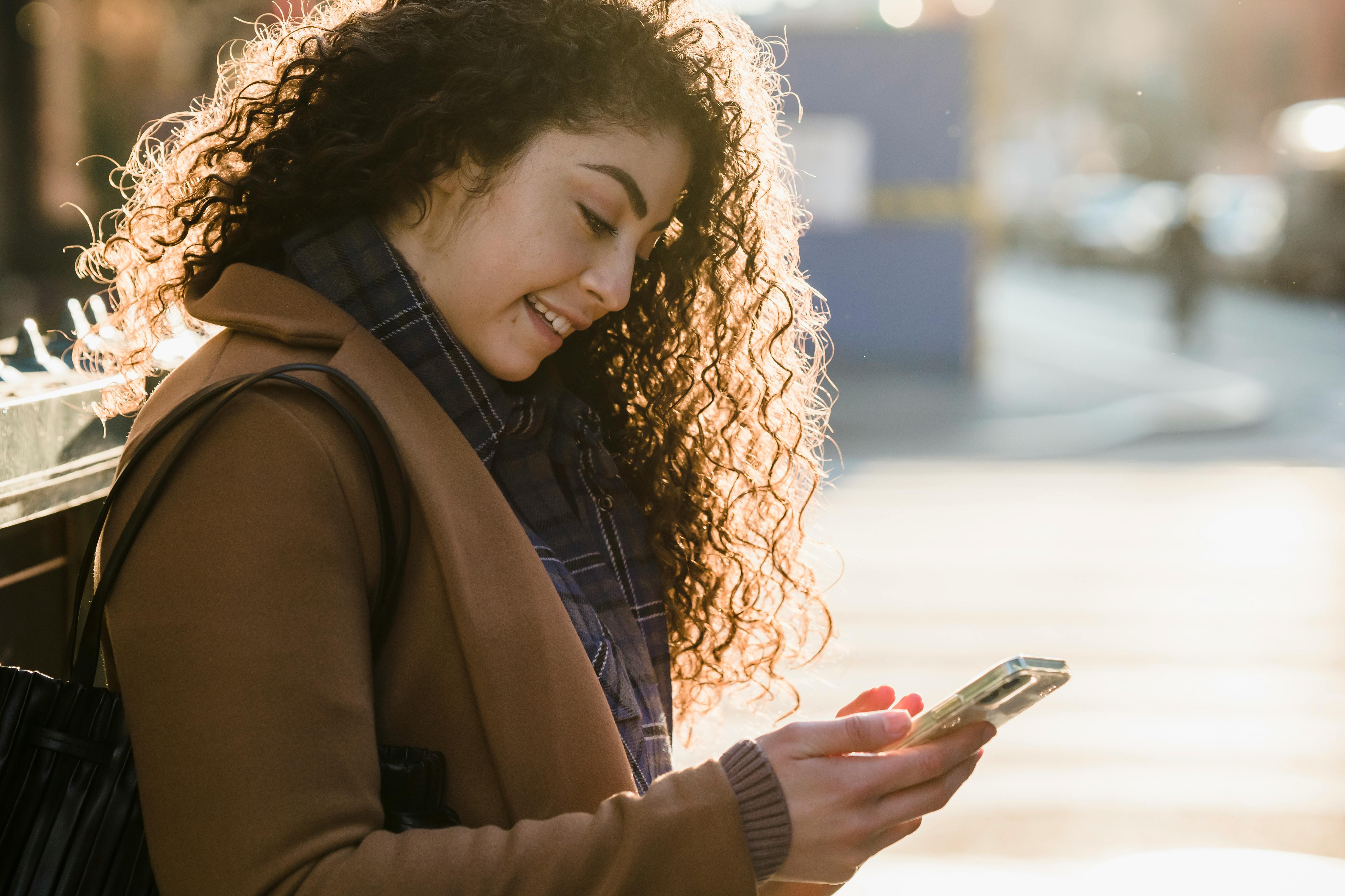 positive woman chatting online on smartphone