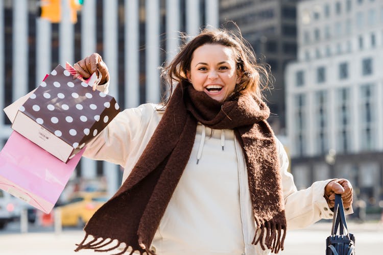 Cheerful Woman In Scarf With Gift Bags Smiling