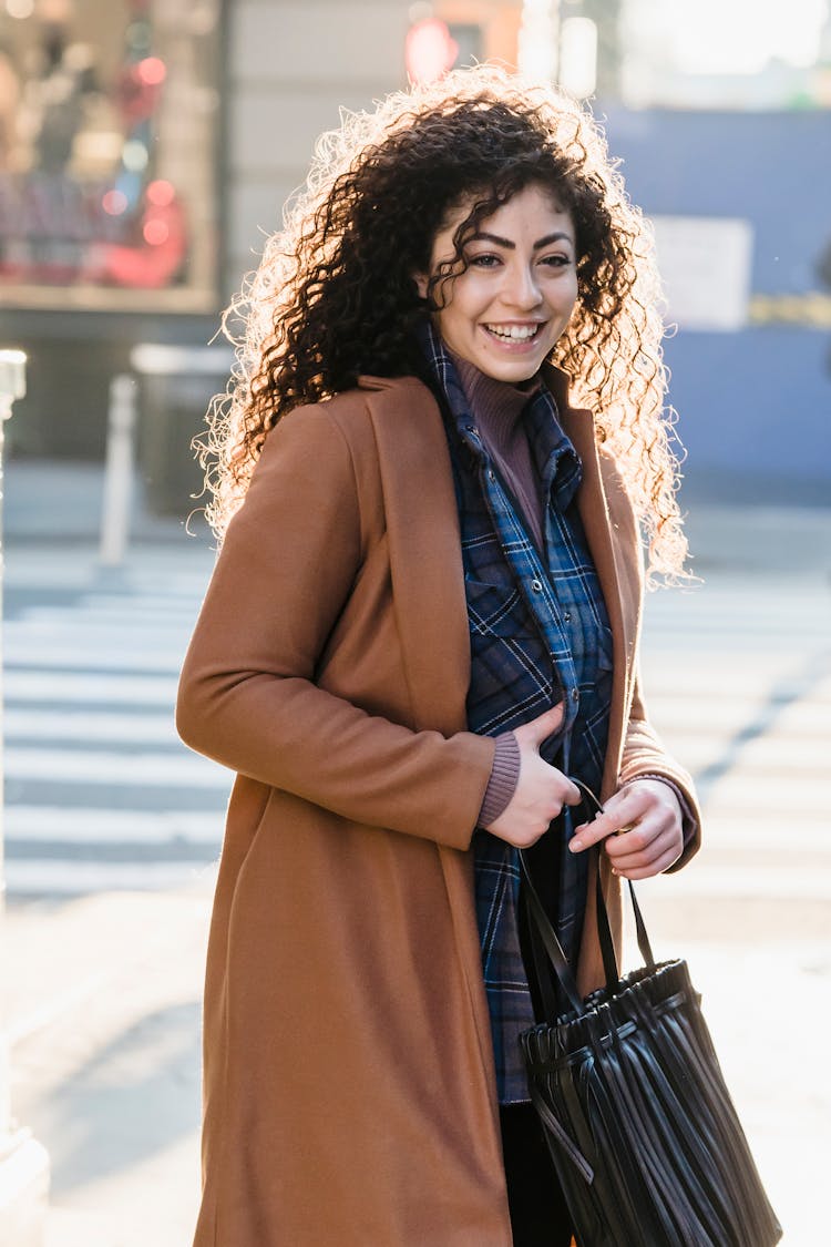 Cheerful Woman With Bag In Trendy Brown Coat Smiling