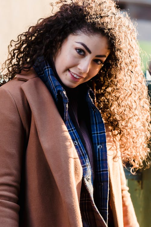 Content young happy woman with curly hair in trendy clothes