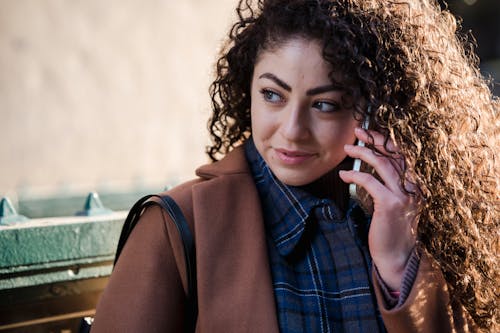 Content young woman talking on smartphone