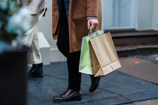 Fashionable woman carrying paper shopping bags in an urban setting.