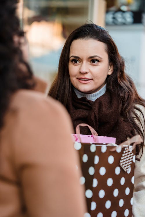 Free Female friends talking to each other after shopping together Stock Photo