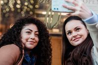 Happy multiethnic women taking selfie in city