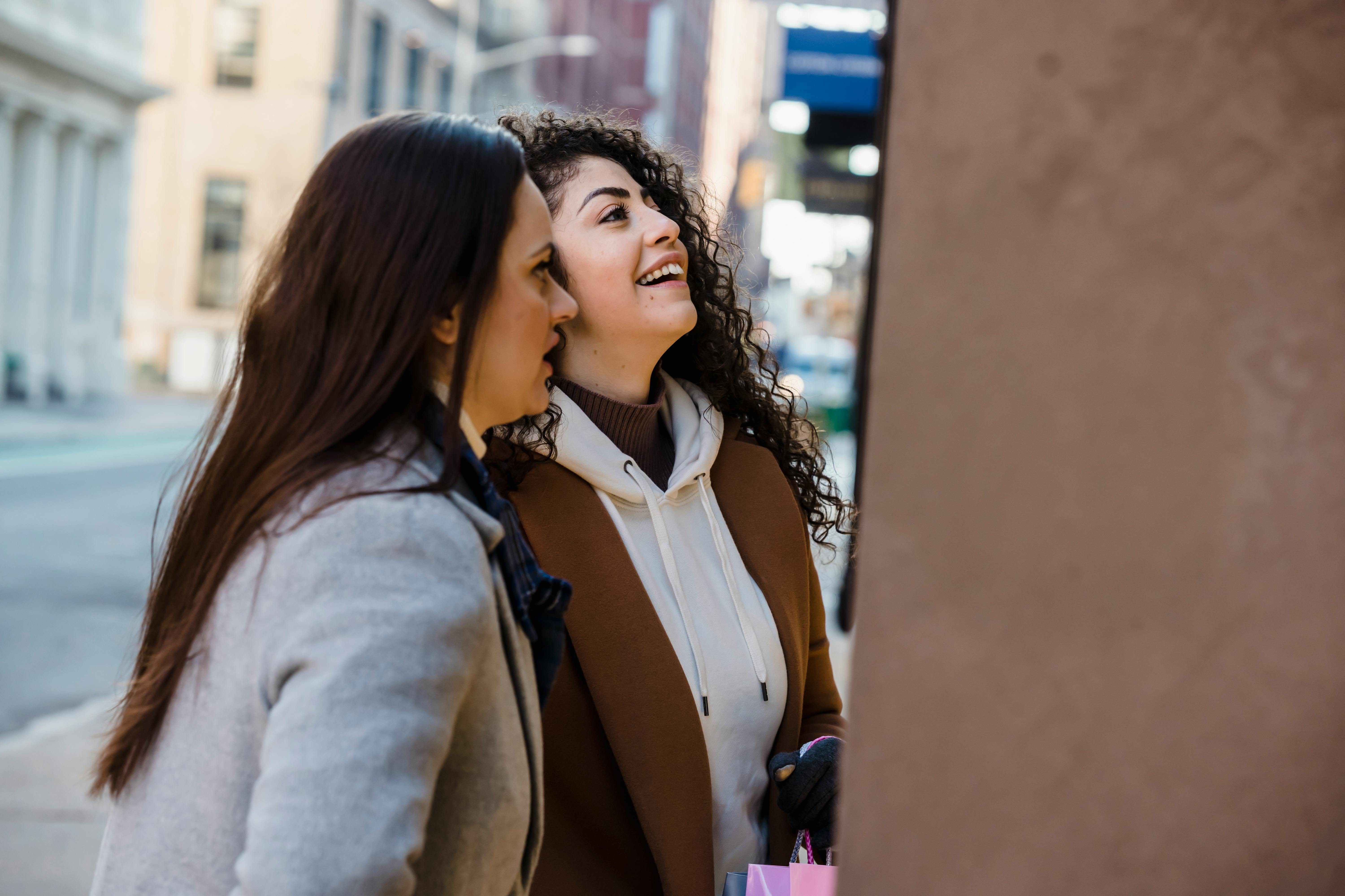 positive multiethnic women standing near store