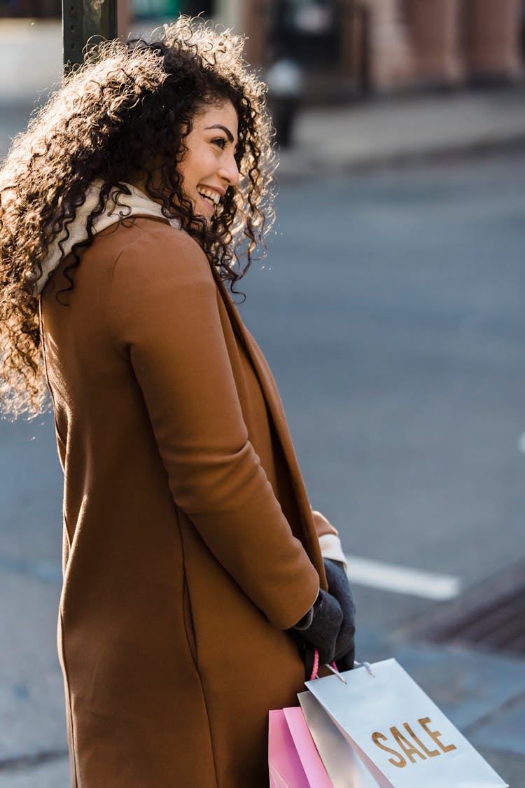 Smiling Woman With Shopping Packages In Street Near Road