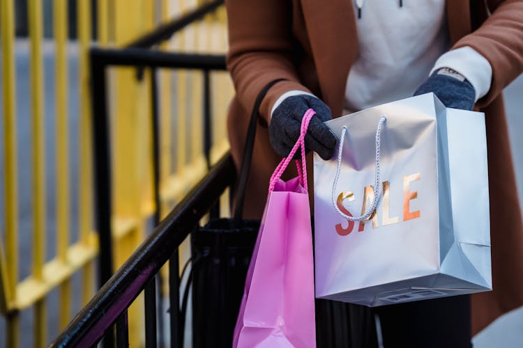 Crop Faceless Woman Looking In Shopping Bags On Spring Street