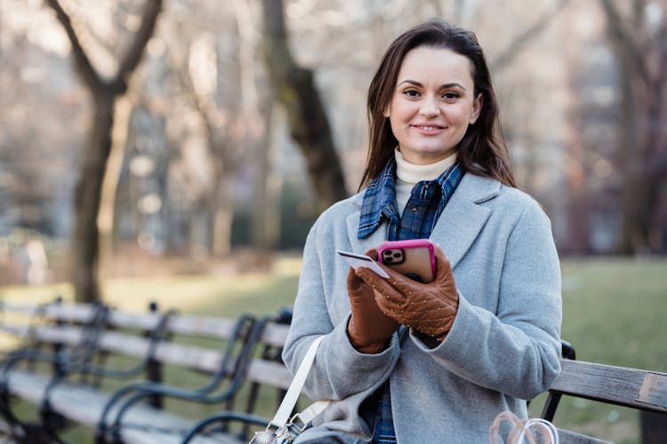 Smiling Woman Using Smartphone On Spring City Park