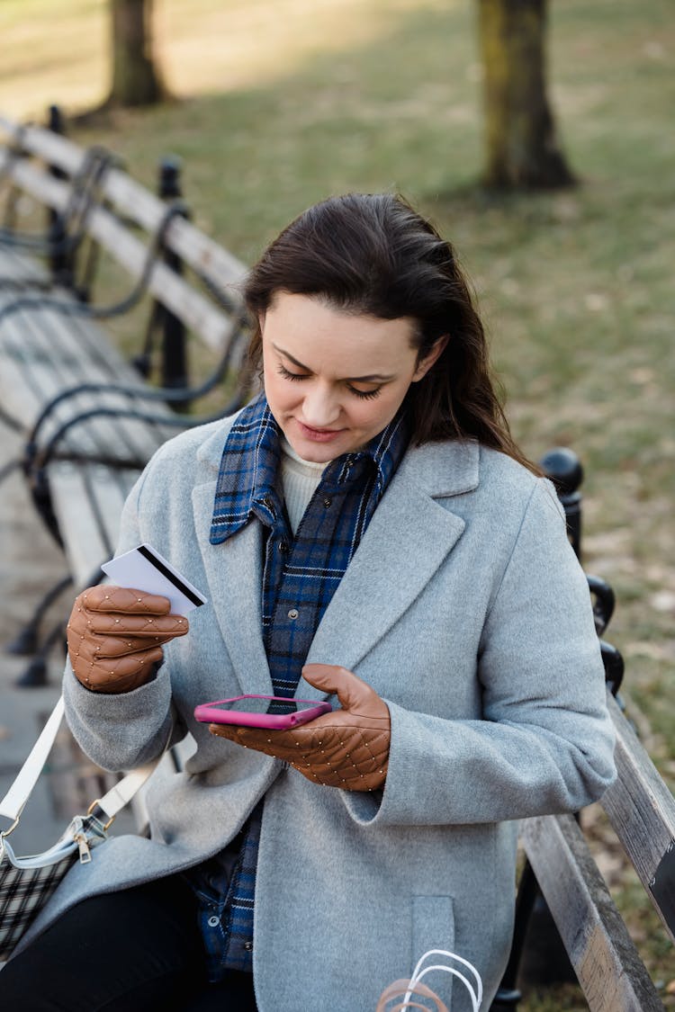 Positive Woman Making Online Transfer Via Smartphone In Park